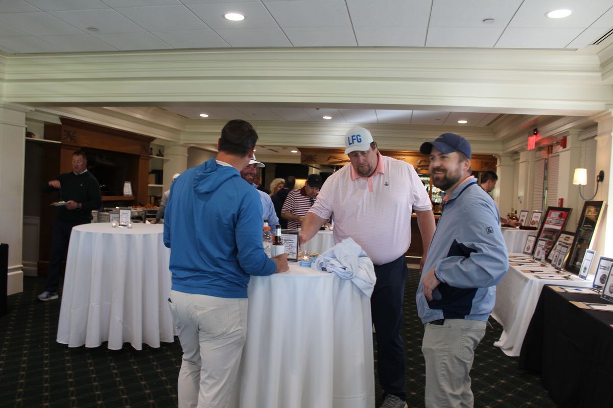 Golfers mingling at the post-round reception and silent auction
